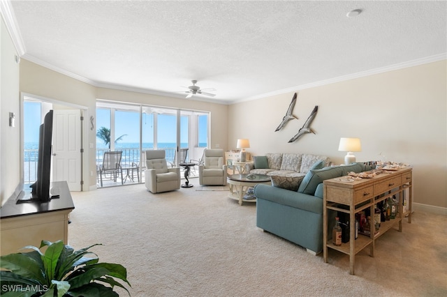 living room with a textured ceiling, carpet floors, a ceiling fan, and crown molding