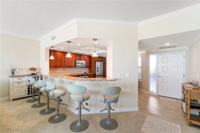 kitchen with backsplash, appliances with stainless steel finishes, a breakfast bar, and crown molding