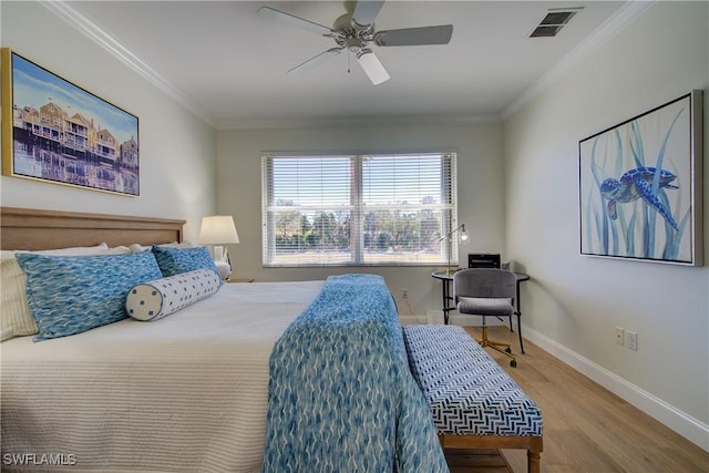 bedroom featuring visible vents, crown molding, baseboards, and wood finished floors