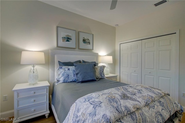 bedroom with baseboards, visible vents, a ceiling fan, dark wood-style flooring, and a closet