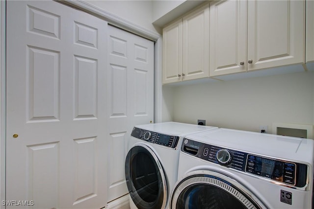 washroom featuring cabinet space and independent washer and dryer