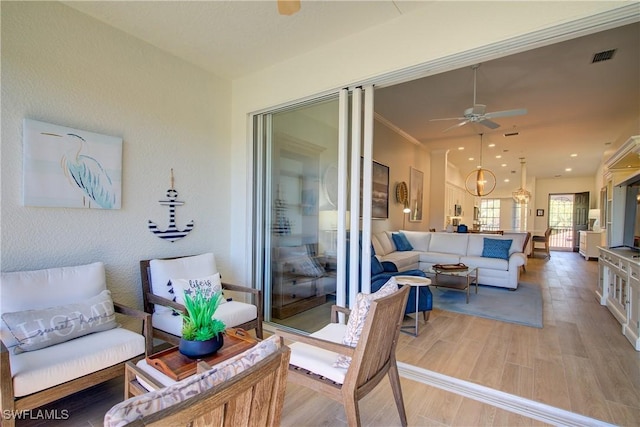 view of patio featuring a ceiling fan, outdoor lounge area, and visible vents