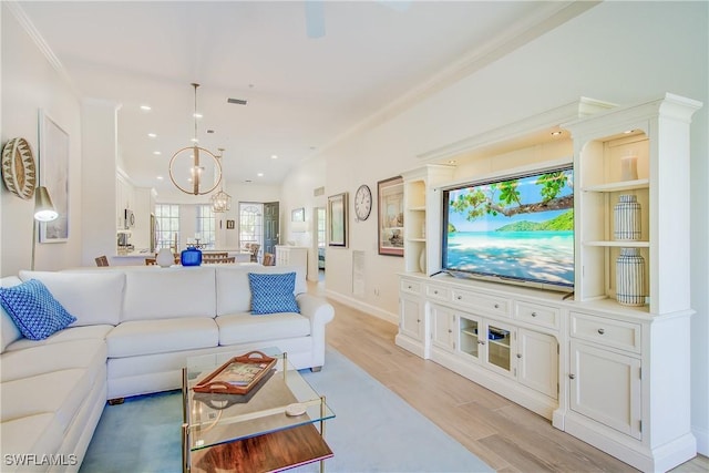 living area with a notable chandelier, recessed lighting, baseboards, light wood-style floors, and crown molding