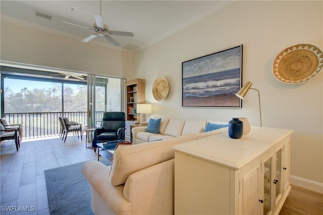 living room featuring ornamental molding, a ceiling fan, visible vents, and wood finished floors