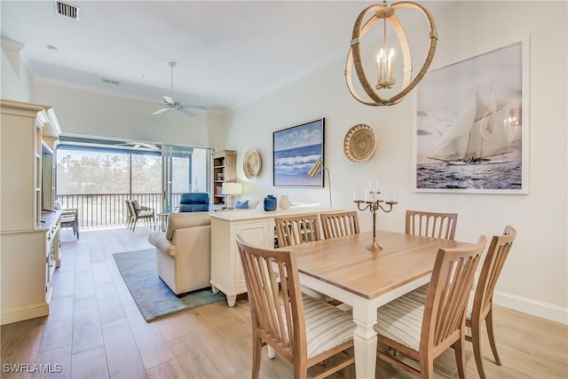 dining area with light wood-type flooring, baseboards, visible vents, and ceiling fan with notable chandelier