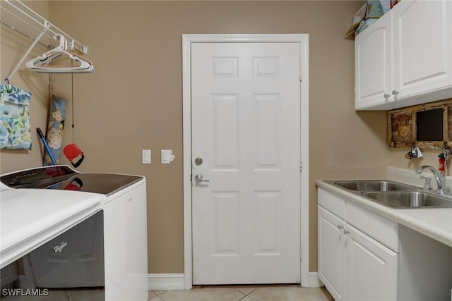 laundry room featuring cabinet space, light tile patterned floors, baseboards, independent washer and dryer, and a sink