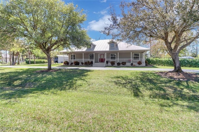 view of front of house featuring covered porch, metal roof, and a front lawn