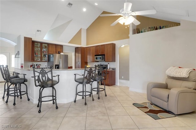 kitchen with appliances with stainless steel finishes, visible vents, a peninsula, and a breakfast bar area