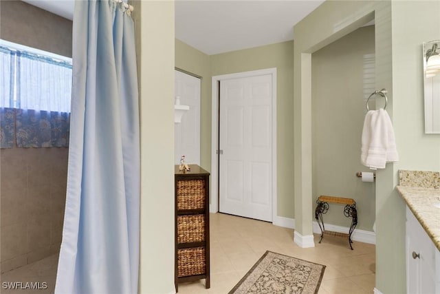 full bath with baseboards, a shower with shower curtain, vanity, and tile patterned floors