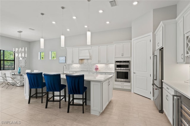 kitchen with visible vents, stainless steel appliances, light countertops, white cabinets, and tasteful backsplash