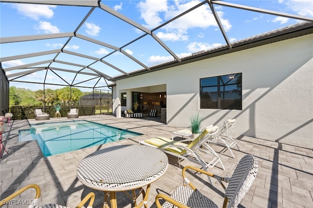 outdoor pool with glass enclosure and a patio area