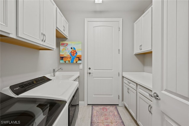 laundry room featuring a sink, cabinet space, and washing machine and dryer