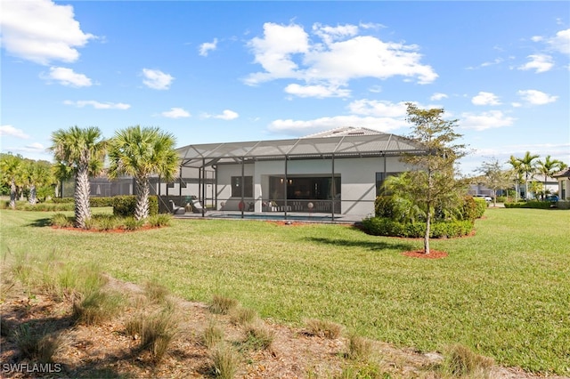 rear view of property with a yard, a lanai, and stucco siding