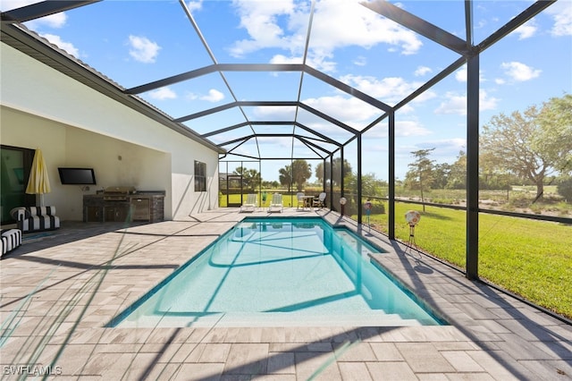 pool featuring glass enclosure, a patio, area for grilling, and a yard