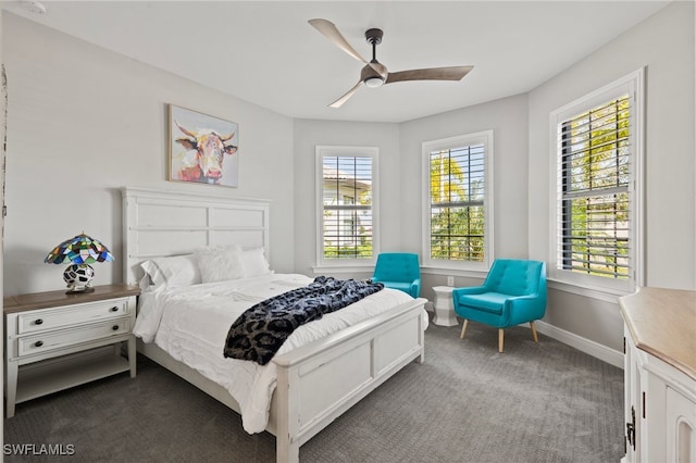 bedroom with a ceiling fan, baseboards, and dark colored carpet