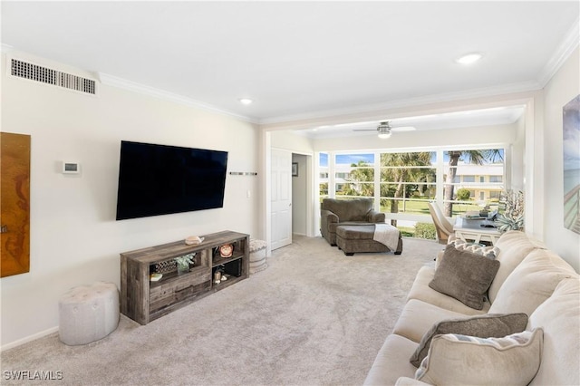 living area featuring ceiling fan, visible vents, baseboards, carpet, and crown molding