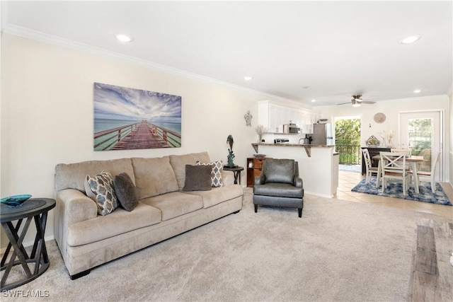 living room featuring light carpet, ornamental molding, a ceiling fan, and recessed lighting