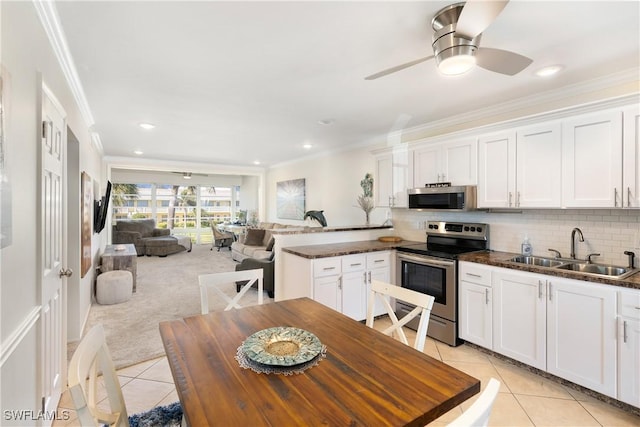 kitchen featuring appliances with stainless steel finishes, backsplash, a sink, and light tile patterned flooring