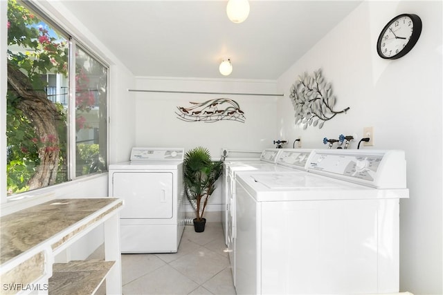 laundry area featuring light tile patterned floors, laundry area, and washing machine and dryer