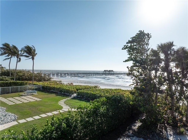 view of water feature with a beach view and fence