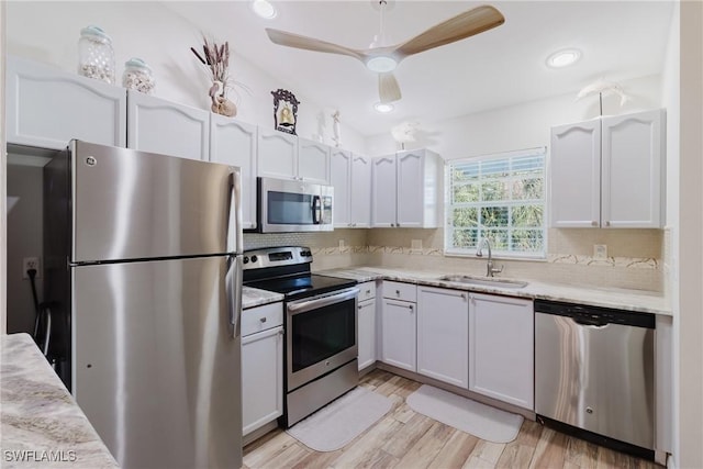 kitchen featuring white cabinetry, a sink, tasteful backsplash, and appliances with stainless steel finishes