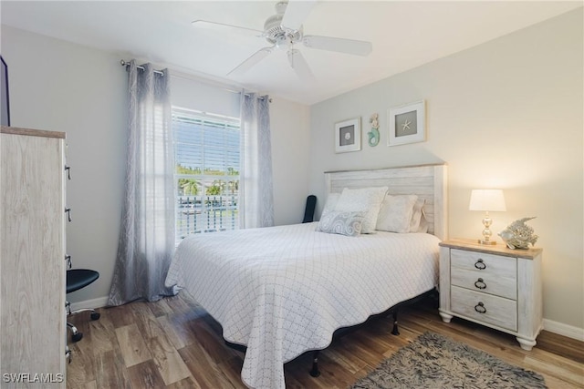 bedroom featuring baseboards, wood finished floors, and ceiling fan