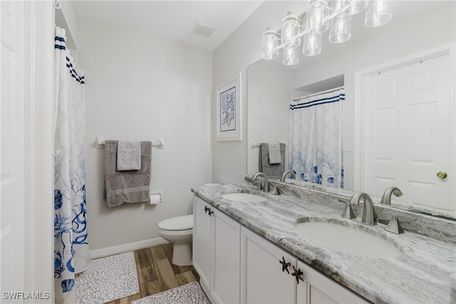 full bathroom with baseboards, a sink, toilet, and wood finished floors