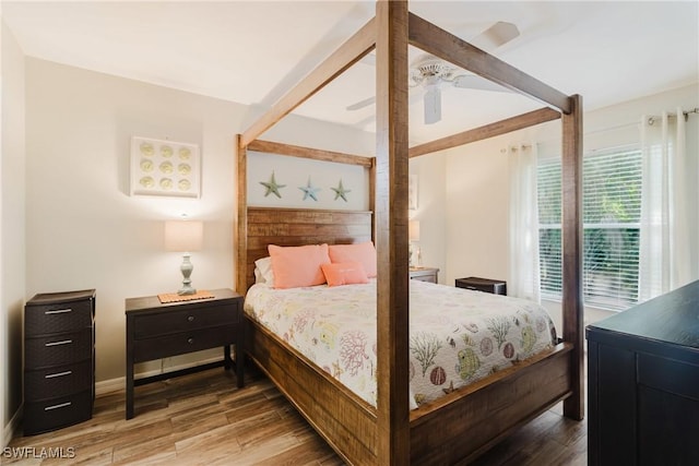bedroom featuring a ceiling fan, baseboards, and wood finished floors
