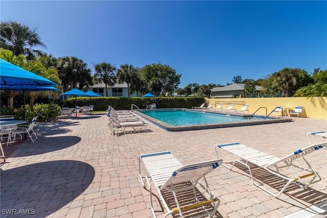 community pool featuring fence and a patio area