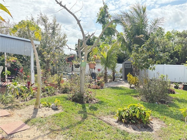 view of yard with a storage shed, fence, and an outbuilding