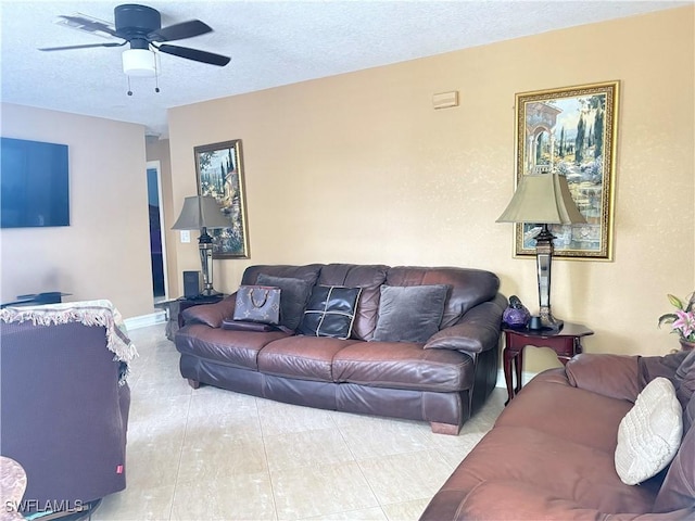 living area featuring a ceiling fan and a textured ceiling