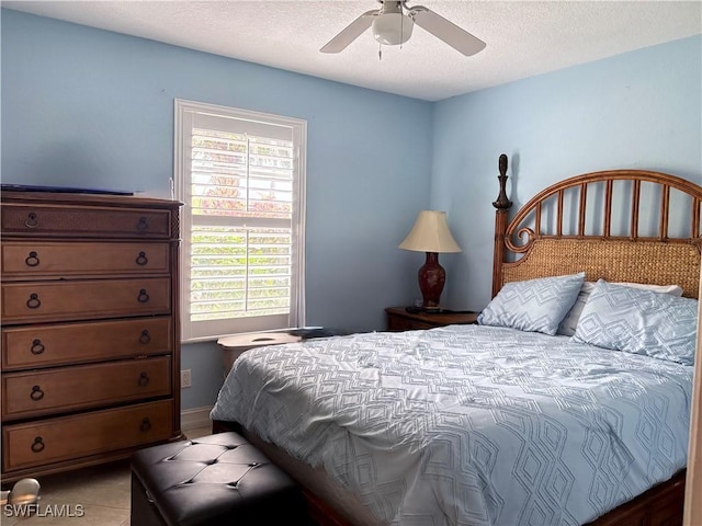 tiled bedroom featuring ceiling fan and a textured ceiling