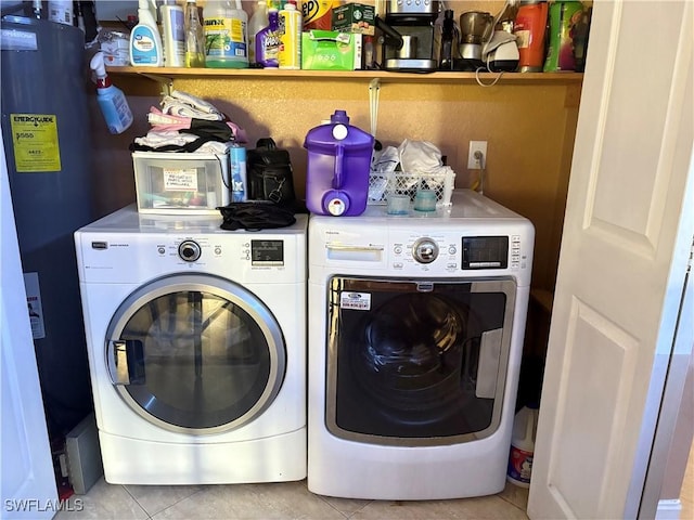 laundry area featuring laundry area, water heater, washer and clothes dryer, and light tile patterned floors