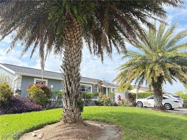 view of front of home featuring stucco siding and a front yard