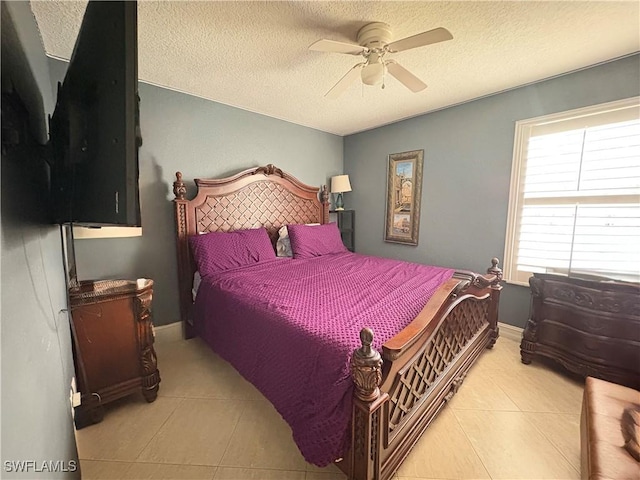 tiled bedroom with a ceiling fan, a textured ceiling, and baseboards