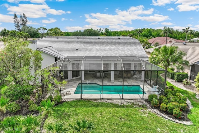 back of property with a patio, an outdoor pool, a yard, and glass enclosure