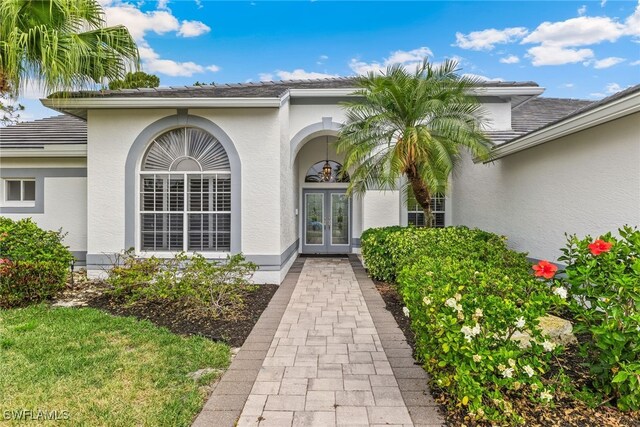 property entrance featuring french doors, stucco siding, and a tile roof