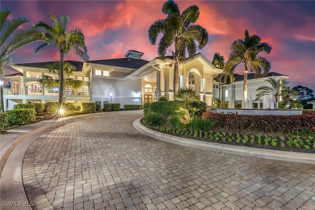 view of front of house featuring curved driveway and stucco siding