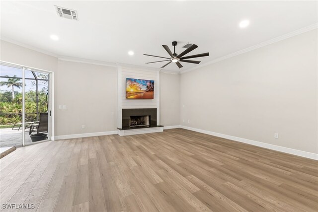 unfurnished living room with ceiling fan, ornamental molding, light wood-style flooring, a large fireplace, and recessed lighting