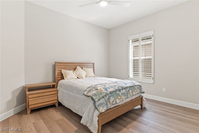 bedroom with light wood-style floors, baseboards, and ceiling fan