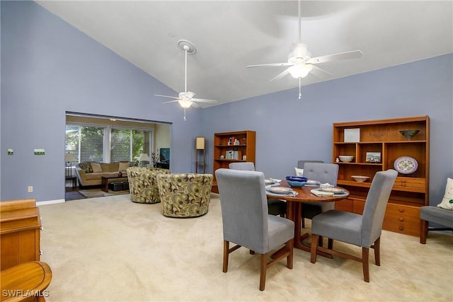 carpeted dining room with baseboards, high vaulted ceiling, and ceiling fan