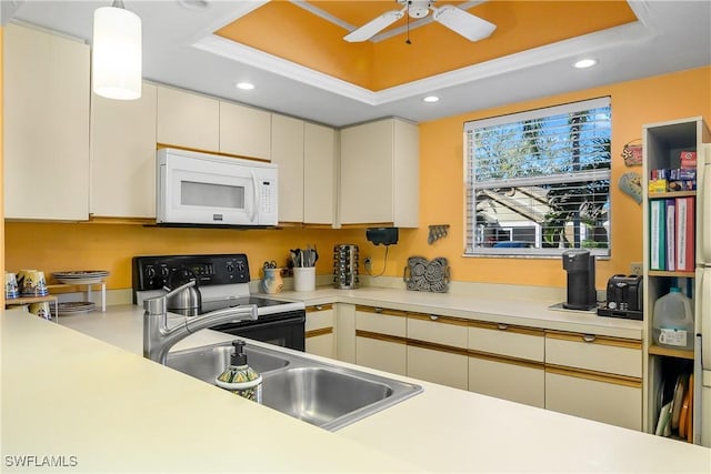 kitchen featuring white microwave, black electric range oven, light countertops, and a raised ceiling