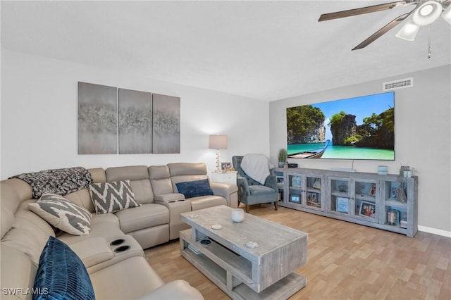 living area featuring baseboards, wood finished floors, visible vents, and a ceiling fan