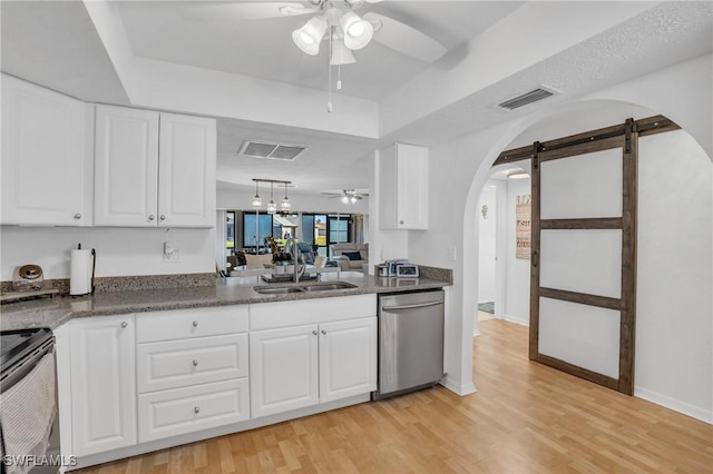 kitchen with arched walkways, a barn door, a sink, a ceiling fan, and stainless steel dishwasher