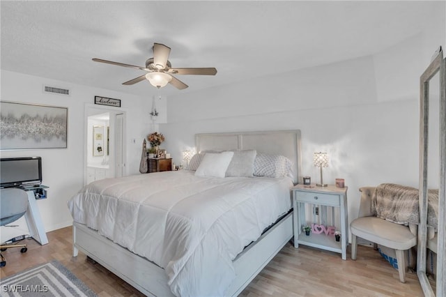 bedroom featuring light wood-type flooring, ensuite bath, visible vents, and baseboards