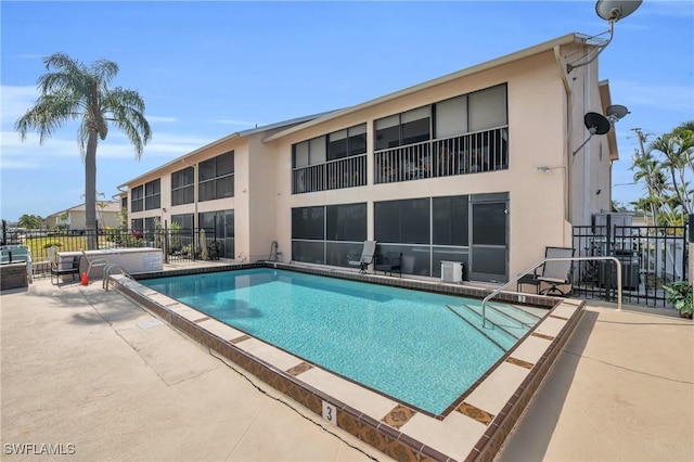 community pool featuring a patio and fence