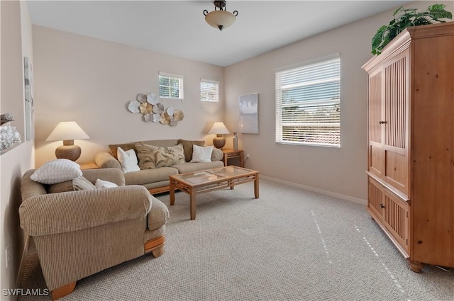 living area with a healthy amount of sunlight, light carpet, and baseboards