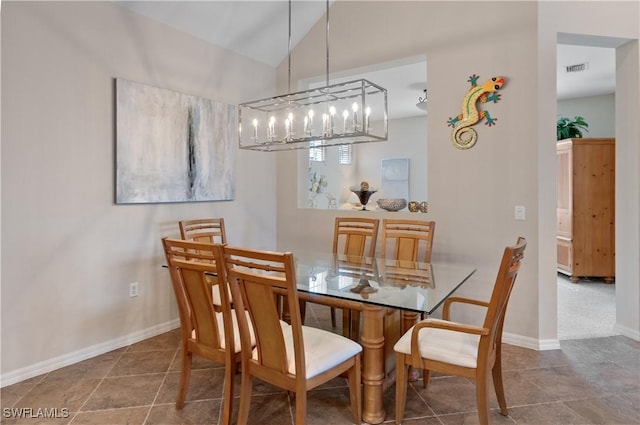 tiled dining space featuring lofted ceiling, visible vents, and baseboards