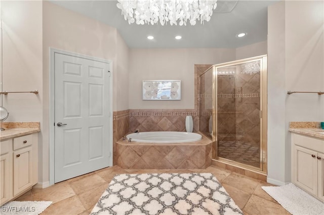 full bath with a stall shower, an inviting chandelier, a garden tub, vanity, and recessed lighting