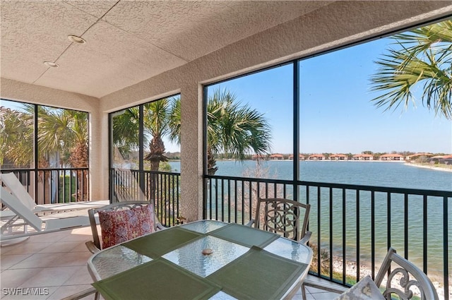 sunroom / solarium featuring a water view